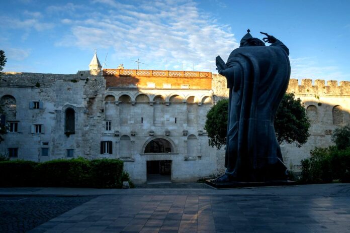 Diocletian's Palace Golden Gate Split Croatia Golden Gate of Diocletian's Palace at sunrise, Split Croatia — Bishop Gregory of Nin statue in foreground